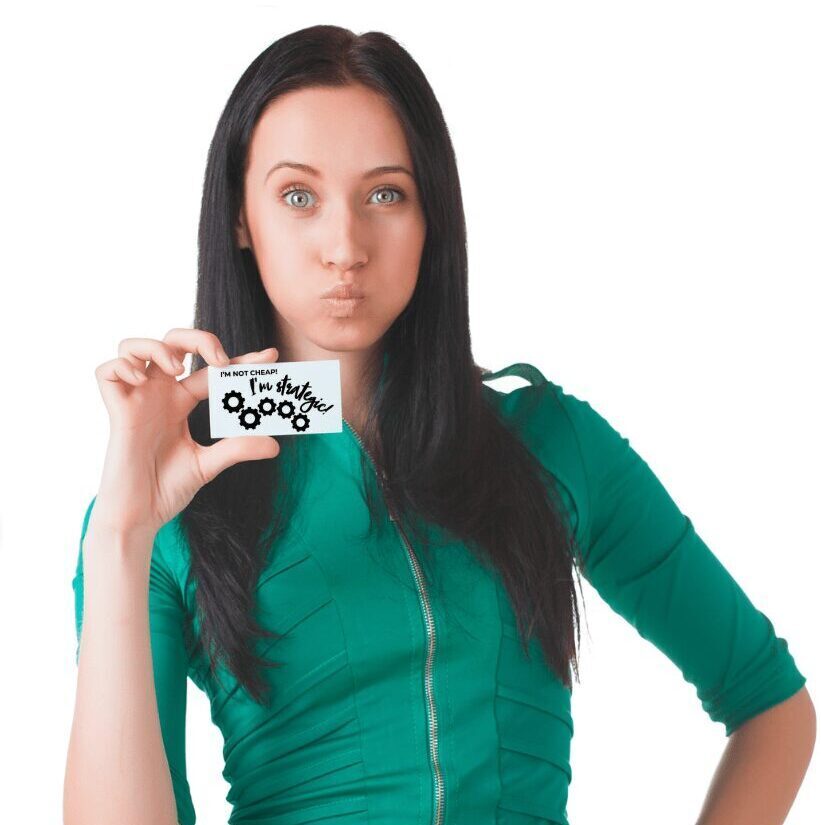 Woman in a green dress holding a card and making a playful, sassy face.
